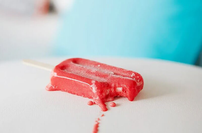 Melting popsicle on an outdoor couch with white, stain-resistant Sunbrella fabric